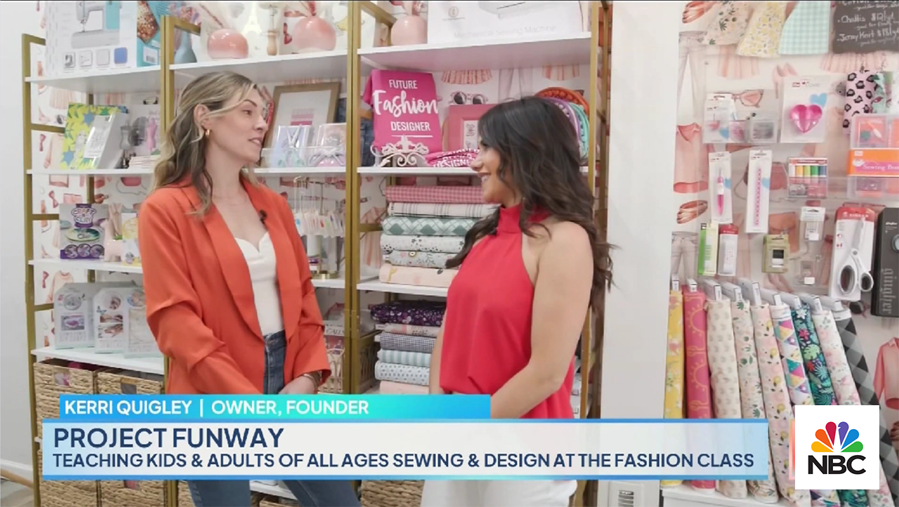 Two women stand and converse in a store filled with fabrics, craft supplies, and fashion-themed items. The woman on the left wears an orange jacket; the one on the right, a red top. Text reads: "Kerri Quigley | Owner, Founder. Project Funway. Teaching kids & adults sewing & design at The Fashion Class." NBC logo in bottom right corner.